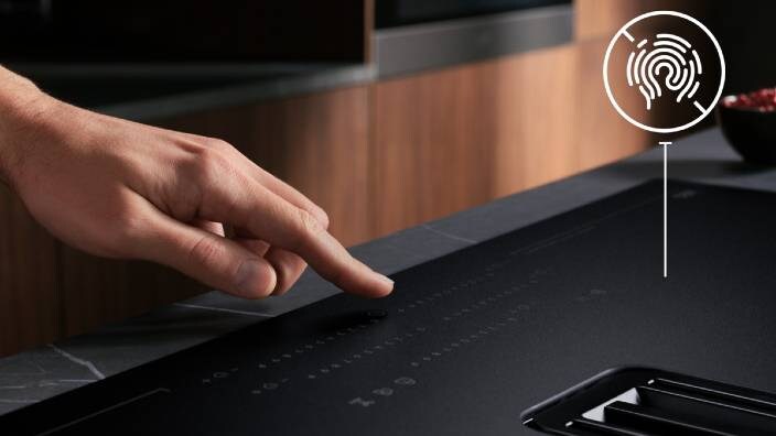 finger touching the hobs settings